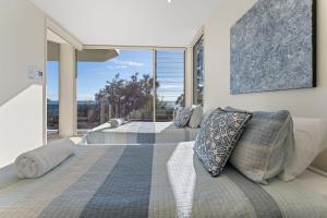 a bedroom with two beds and a large window at Mirage 1 24 Gloucester Street in Nelson Bay