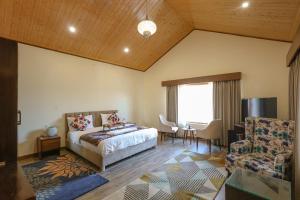 a bedroom with a bed and a table and a chair at Dancing Deer Chalet in Kūfrī
