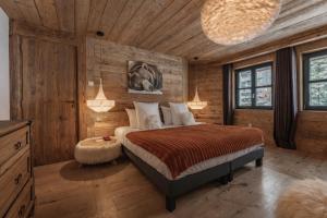 a bedroom with a bed and a wooden wall at Chalet Face - LES CHALETS COVAREL in Val-d'Isère +20 photos