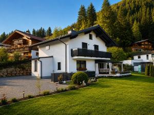 a white house with a black roof at My Appartements in Untertauern