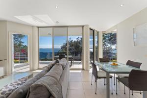 a living room with a couch and a glass table at Mirage 1 24 Gloucester Street in Nelson Bay