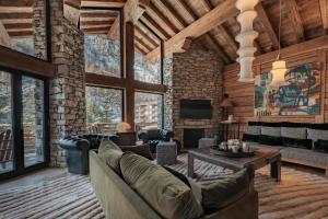a living room with couches and a fireplace at Chalet Face - LES CHALETS COVAREL in Val-d'Isère