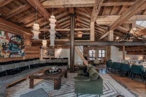 an open living room with wooden ceilings and a table and chairs at Chalet Face - LES CHALETS COVAREL in Val-d'Isère