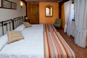 a bedroom with two white beds and a mirror at Casa Del Palacio in Aguilafuente