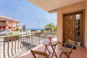 a patio with a table and chairs on a balcony at Il Vulcano di Milo in Milo