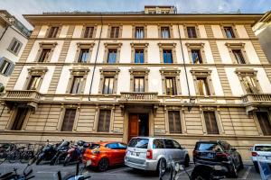 a large building with cars parked in front of it at Five Suites Mantellate 9 in Florence