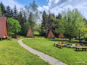 a group of tents in a field with benches at Moto Keja Bieszczady in Uherce Mineralne (7)