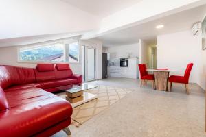 a living room with a red couch and a table at Luxury Family Apartment with Terrace FRIGO in Maribor