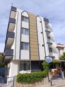 a tall building with a sign in front of it at Odak Pansiyon in Çanakkale