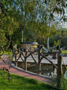 a wooden fence in a park next to a body of water at At the old blacksmith in Daugavpils