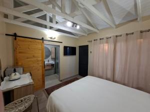 a bedroom with a white bed and a wooden door at De Windmolen in Centurion
