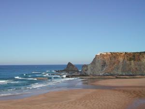 una spiaggia con formazione rocciosa nell'oceano di Ponta Branca Beach House a Odeceixe