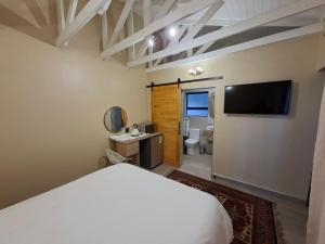 a bedroom with a bed and a flat screen tv at De Windmolen in Centurion