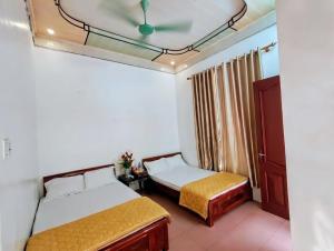 a bedroom with two beds and a ceiling at Tùng Linh Hotel in Sầm Sơn