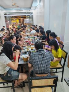 a group of people sitting at tables eating food at Tùng Linh Hotel in Sầm Sơn