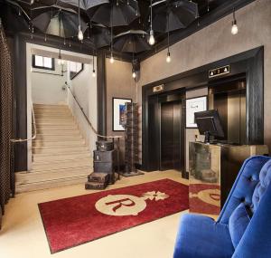 a lobby with a blue couch and a red rug at The Rex - formerly Hotel Gotham in Manchester