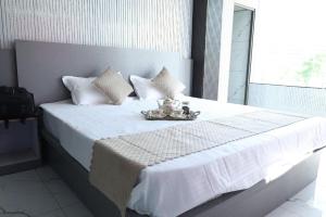 a bedroom with a white bed with a tray on it at Hotel The Mount View in Rājgīr