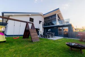 a yard with a swing and a house at Luxury Family Apartment with Terrace FRIGO in Maribor