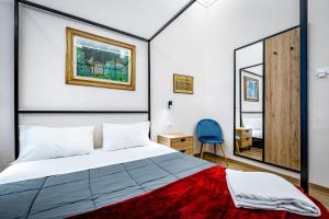 a bedroom with a large bed and a mirror at Five Suites Mantellate 9 in Florence