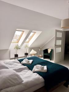a bedroom with a large bed with two towels on it at Apartament Perełka in Darłowo