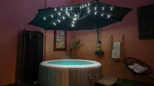 a hot tub in a room with an umbrella at Dejavu Terrace Setúbal in Setúbal