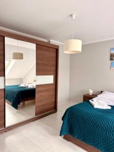 a bedroom with a large mirror and a bed at Apartament Perełka in Darłowo