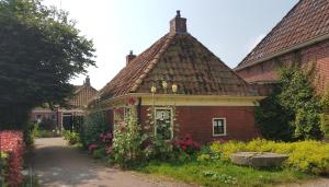 a house with flowers on the side of it at Lutje Hoeske in Tinallinge