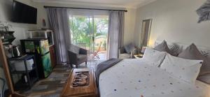 a bedroom with a bed and a sliding glass door at 54 on Asteria 2 in Amanzimtoti +12 photos