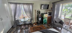a living room with a table and a chair at 54 on Asteria 2 in Amanzimtoti