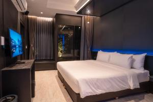 a bedroom with a bed and a flat screen tv at morph Bangkok Hotel in Bangkok