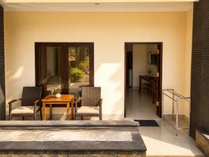 a patio with two chairs and a wooden table at Radha Bali Hotel in Kuta