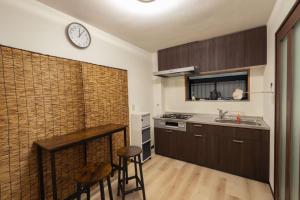 a kitchen with a counter and a clock on the wall at 暖迎の宿 in Tokyo +19 photos