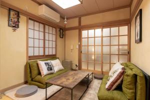 a living room with a green couch and a table at 暖迎の宿 in Tokyo