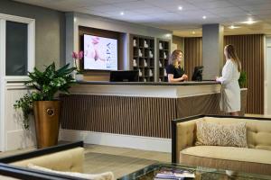 two women standing at a reception counter in a salon at The Belfry Hotel & Resort in Sutton Coldfield +91 photos
