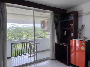 a room with a balcony with a sliding glass door at NJ INTHAI Hotel in Sathani Chiang Rak