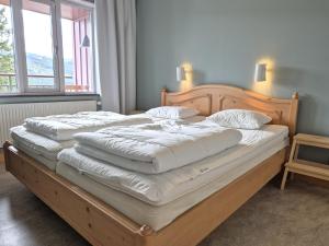 two twin beds in a room with two windows at AGO Nya Lundsgården in Åre