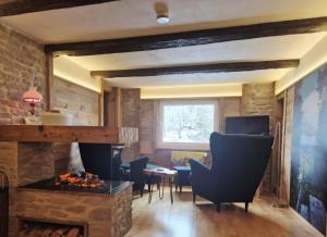 a living room with a fireplace and chairs and a table at Zum fröhlichen Eichhörnchen in Feldberg