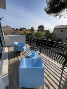 a balcony with two blue chairs and a table at Carro Zen in Martigues +20 photos