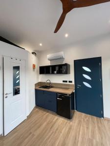 a kitchen with a sink and a blue door at Carro Zen in Martigues