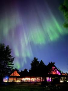 an image of the northern lights in the sky over a building at Yllästar 3 - Cozy Stay in Magical Lapland in Äkäslompolo