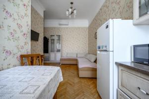 a room with a bed and a refrigerator in it at Grecheskaya Central Suites in Odesa