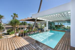 a swimming pool with a pergola on a wooden deck at Villa Liquen in Yaiza
