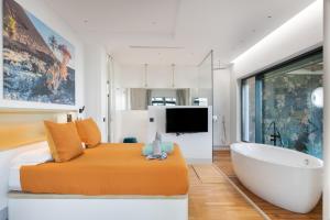 a bedroom with a bed and a tub and a television at Villa Liquen in Yaiza