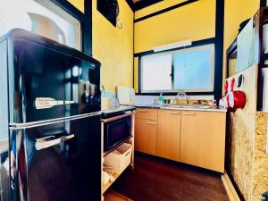 a kitchen with a black refrigerator and a sink at 風乃釣り宿 in Shirahama