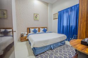 a bedroom with a bed and a blue curtain at صدي للشقق المخدومة in Khamis Mushayt +45 photos