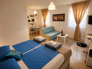 a bedroom with a blue bed and a living room at AMD Infinity Suites in Split