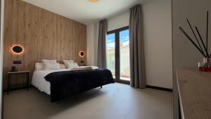 a bedroom with a bed and a large window at HS Olivos in Alcalá del Júcar