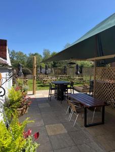 a patio with tables and chairs and an umbrella at The World's End in Lowdham