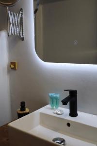 a bathroom with a sink with a mirror at Sarizas Apartments in Siviri