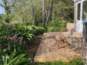 a porch with a chair and a table and flowers at La Mer self-catering in Sark